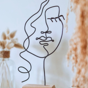 Visage de femme en fil de fer sur socle en bois