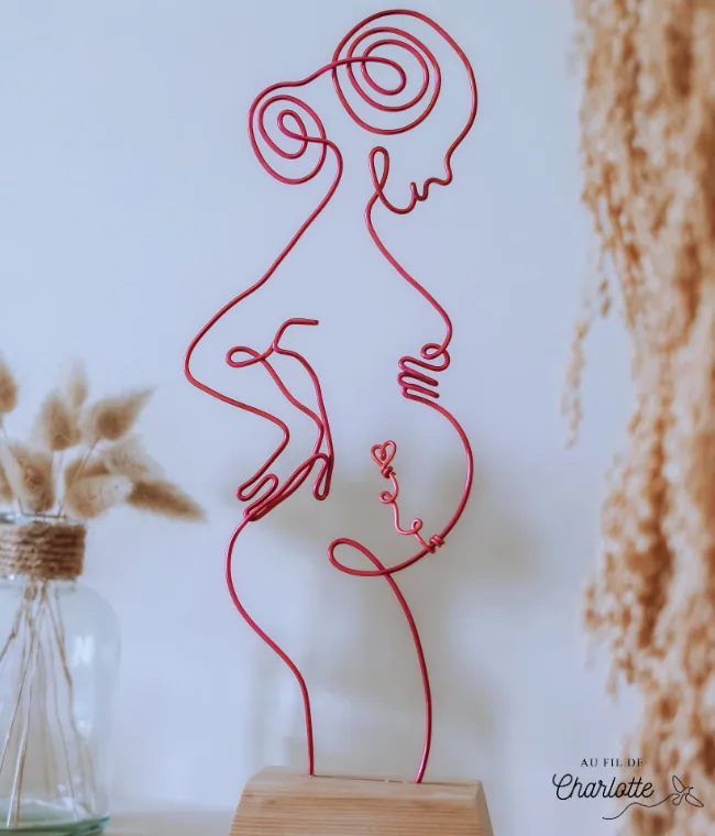Femme enceinte en fil de fer sur socle en bois