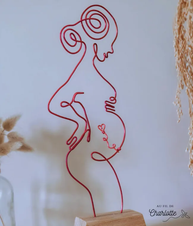 Femme enceinte en fil de fer sur socle en bois