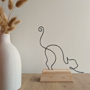 Chat qui s'étire sur socle en bois