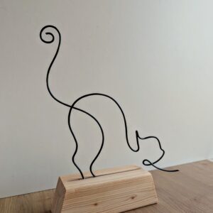 Chat qui s'étire sur socle en bois