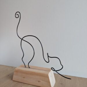 Chat qui s'étire sur socle en bois
