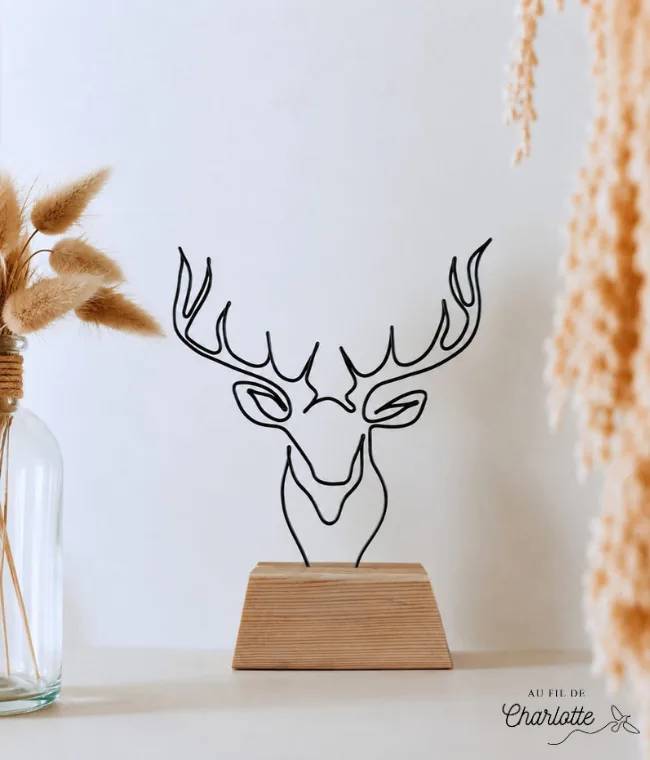Tête de cerf en fil de fer sur socle en bois