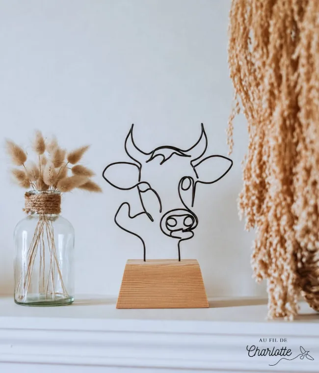 Tête de vache en fil de fer sur socle en bois